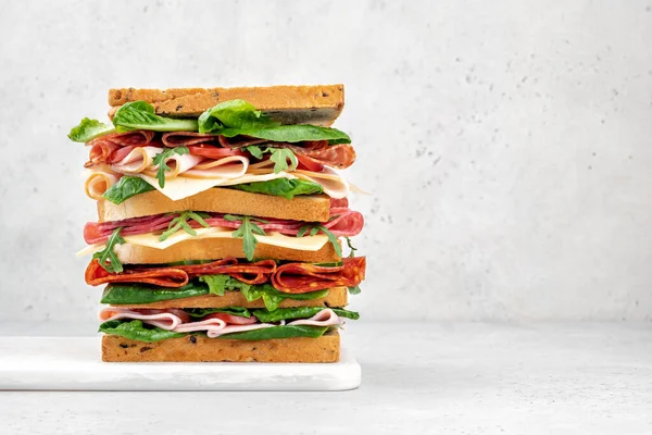 Velký chutný sendvič se šunkou, salátem, sýrem a rajčaty — Stock fotografie
