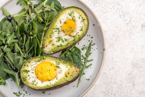 Pequeno-almoço saudável. Abacate recheado com ovos na mesa — Fotografia de Stock