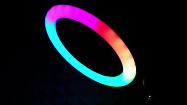 Parlak yüzük rgb lambası. Karanlık bir odada çok renkli bir ışık, yakın plan..