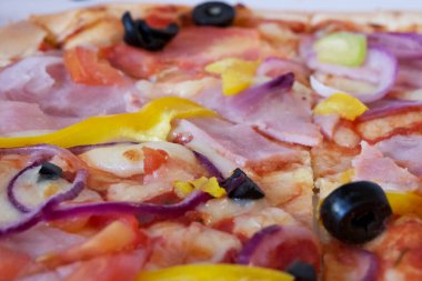 Jambonlu pizza, domates, tatlı biber ve zeytin, yakın çekim..