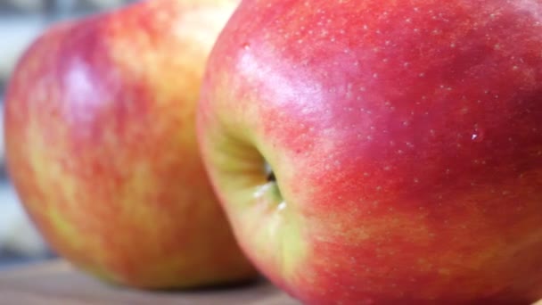 3つの赤いリンゴが閉じます やわらかさと甘みのあるリンゴの品種で 縞模様や斑状の外観が特徴です — ストック動画