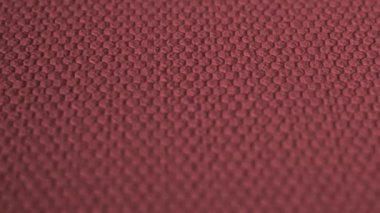 Kabartmalı bordo kumaş. Renkli bir yüzeyde geometrik desen.