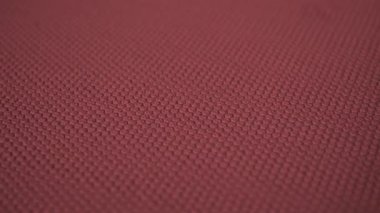 Kabartmalı bordo kumaş. Renkli bir yüzeyde geometrik desen.
