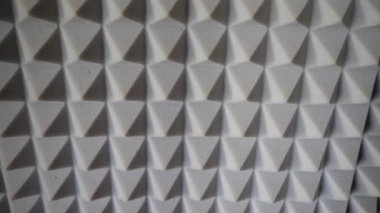 Ses geçirmez köpük piramitleri yakın plan. Gürültü bastırma aracı. Gri akustik köpük. Akustik köpük, akustik tedavi için kullanılan açık hücreli bir köpüktür. Hava yoluyla yayılan ses dalgalarını azaltır..