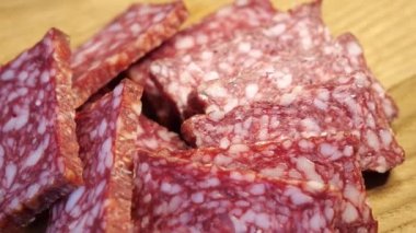 Dönen bir yüzeyde tütsülenmiş sosis parçaları.