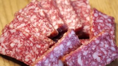 Dönen bir yüzeyde tütsülenmiş sosis parçaları. Yiyecek.