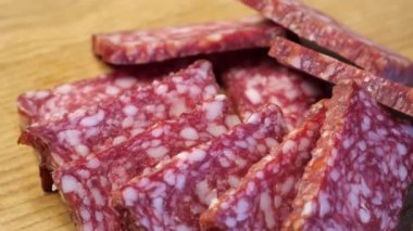 Dönen bir yüzeyde tütsülenmiş sosis parçaları. Yiyecekler yakın plan..