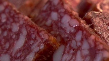 Birkaç parça sosis yakın plan. Salam, tam kare. Tam HD video, seçici odaklanma. Sosisi dilimliyorum. Çiğ sosis ürünü, makro shot.