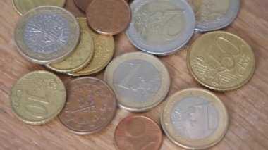 Değişen ahşap bir yüzey üzerinde Avrupa Birliği 'nin çeşitli metal paraları. Avrupa sikkeleri yakın plan. Yüksek detaylı makro video, 4k çözünürlük.