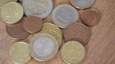 Değişen ahşap bir yüzey üzerinde Avrupa Birliği 'nin çeşitli metal paraları. Avrupa sikkeleri yakın plan. Son derece detaylı makro video.