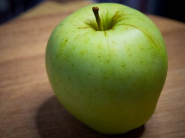 Ahşap bir yüzeyde büyük bir elma, yan manzara. Apple yakın çekim.