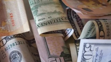 Dönüşümlü dolar banknotları ve çeşitli banknotlar yakın çekim. Dolarların ve avroların geçmişi. 4K makro video. Kağıt paranın makro görüntüsü