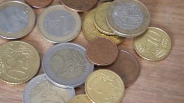 Değişen ahşap bir yüzey üzerinde Avrupa Birliği 'nin çeşitli metal paraları. Avrupa sikkeleri yakın plan. Son derece detaylı video.