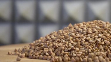 Dönen ahşap bir yüzey üzerinde karabuğday, yakın çekim video. Detaylı video 4k biçiminde, metin için boşluk. Makrovideo karabuğday.