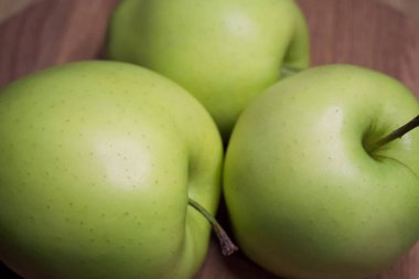 Tahta bir yüzeyde üç elma, yakın plan bir çekim..