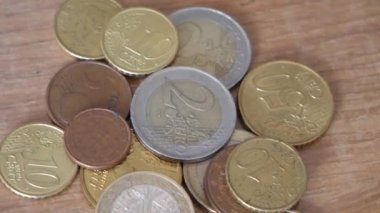 Değişen ahşap bir yüzey üzerinde Avrupa Birliği 'nin çeşitli metal paraları. Avrupa sikkeleri yakın çekim, ayrıntılı video.