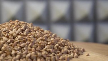 Dönen ahşap bir yüzey üzerinde karabuğday, yakın çekim video. Detaylı video 4k biçiminde, metin için boşluk. Makrovideo.