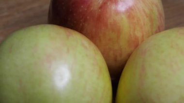 Three big beautiful apples on a rotating surface. Macro video. Fruit rotation close-up.