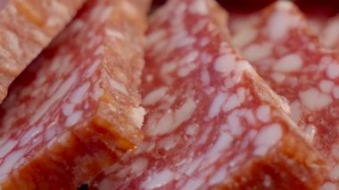 Salam, tam kare. Tam HD video, seçici odaklanma. Sosisi dilimliyorum. Çiğ sosis, makro shot.