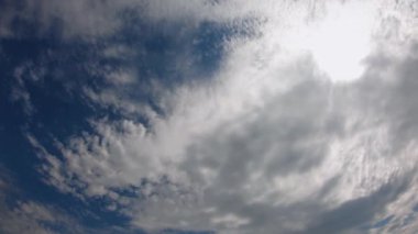 Güzel beyaz bulutlar mavi gökyüzünde hızla hareket eder. Zaman ayarlı video. Arka plan olarak gökyüzü. Güneşli sıcak hava.