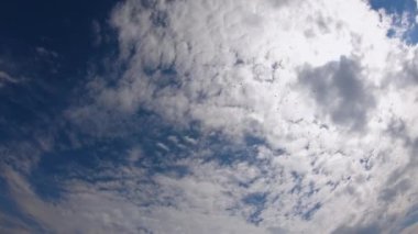 Güzel beyaz bulutlar mavi gökyüzünde hızla hareket eder. Zaman ayarlı video. Arka plan olarak gökyüzü. Güneşli sıcak hava. Gökyüzünde değişebilir bulutlar