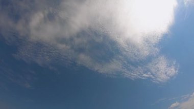 Güzel beyaz bulutlar mavi gökyüzünde hızla hareket eder. Zaman ayarlı video. Arka plan olarak gökyüzü. Güneşli sıcak hava. Değiştirilebilir bulutlar