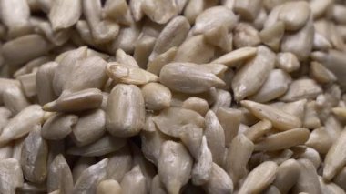 Sırayla çiğ ayçekirdeği. Stüdyo çekimi. Soyulmuş Helianthus Annuus tohumları. Makro video. Seçici odaklanma. Sağlıklı yiyecek, süper tohum kavramı.