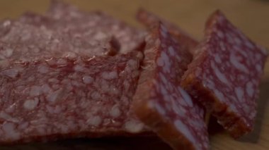 Dönen ahşap bir yüzey üzerinde dikdörtgen salam parçaları.