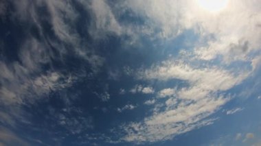 Güzel beyaz bulutlar mavi gökyüzünde hızla hareket eder. Zaman ayarlı video. Güneşli hava.