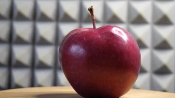 Ein Schöner Roter Apfel Auf Einer Rotierenden Holzoberfläche Vor Grauem — Stockvideo