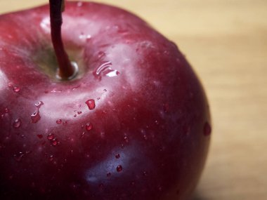 Kırmızı bir elmanın üzerindeki su damlacıkları. Kırmızı Şef 'in elmasının makro pozu..