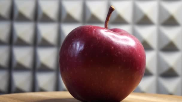Ένα Όμορφο Κόκκινο Μήλο Περιστρεφόμενη Ξύλινη Επιφάνεια Πάνω Γκρι Φόντο — Αρχείο Βίντεο
