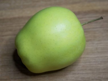 Tahta bir yüzeyde bir altın tarla elması. Yakın çekim..