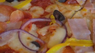 Jambonlu, zeytinli ve domatesli İtalyan pizzası. Pizza yakın çekim, tam HD video çözünürlüğü.