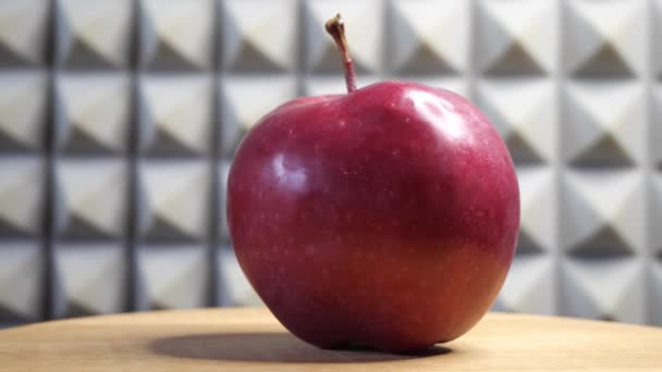 Jedno Krásné Červené Jablko Rotujícím Dřevěném Povrchu Pozadí Šedé Stěny — Stock video