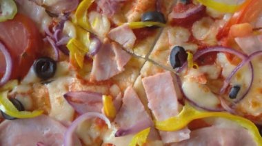 Jambonlu, zeytinli ve domatesli İtalyan pizzası. Pizza yakın plan..