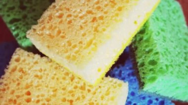 Mutfak süngerinin 4K görüntüsü. Çeşitli renkli süngerler, 4k makro video, döndürme.