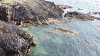 Resimli kayalık oluşumlar. Kelt Denizi 'nin kayalık kıyıları. Deniz suyu kayalara çarpar..