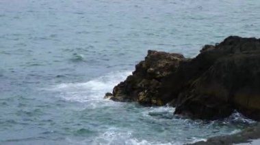 Kıyı kayalarında deniz dalgaları kırılır. Atlantik Okyanusu 'nun suları. Deniz Burnu. El bilgisayarı videosu.