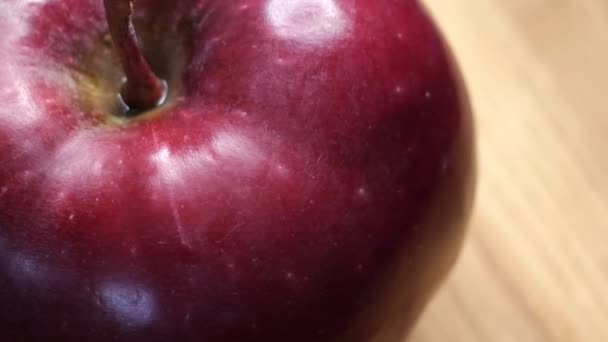 1つの大きな赤いリンゴが回転し クローズアップビデオ リンゴの皮のハイライト 4Kマクロビデオ おいしい熟した果物 レッドチーフ品種のアップル — ストック動画