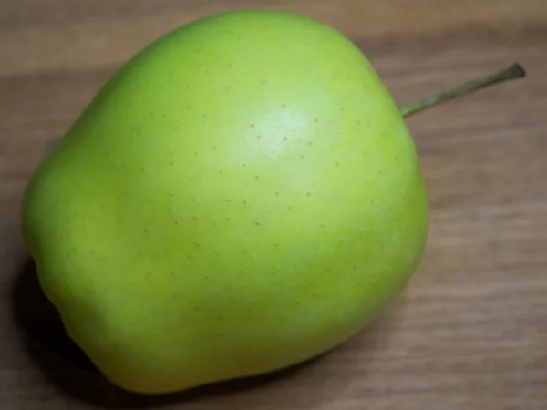 木製の表面に黄金の品種の1つのリンゴ クローズアップショット — ストック写真