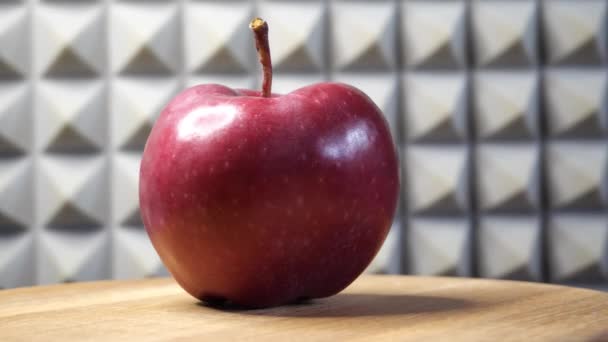 Jedno Červené Jablko Otočném Povrchu Šedém Pozadí — Stock video
