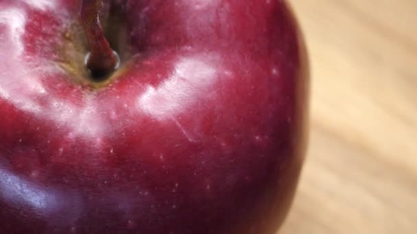 1つの大きな赤いリンゴが回転し クローズアップビデオ リンゴの皮のハイライト 4Kマクロビデオ おいしい果物 レッドチーフ品種のアップル — ストック動画