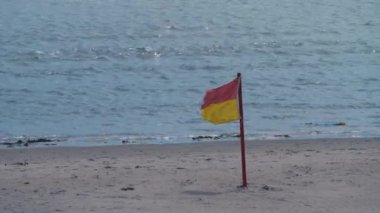 Sahilde kırmızı ve sarı bayrak. Kurtarıcılar tarafından korunan bölgeyi belirleyen bayrağa yüzme izni verildi..