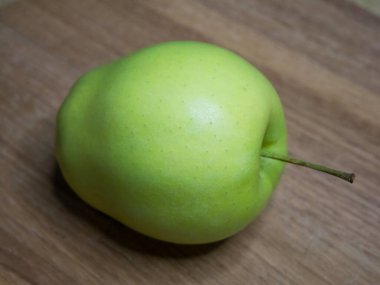 Tahta bir yüzeyde bir altın tarla elması. Yakın çekim..