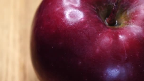 1つの大きな赤いリンゴが回転し クローズアップビデオ リンゴの皮のハイライト 赤のチーフ品種のアップル 4Kマクロビデオ — ストック動画