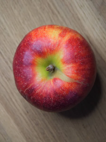 木製のテーブルの上に1つの大きな赤いリンゴ クローズアップショット トップ表示 — ストック写真