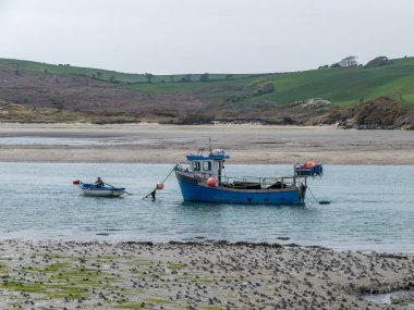 West Cork, İrlanda, 30 Nisan 2022. Sığ sularda bir balıkçı teknesi. Teknede bir adam var. Deniz manzarası.
