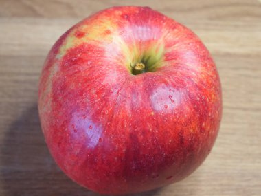 Ahşap bir arka planda büyük kırmızı bir elma, yakın çekim..