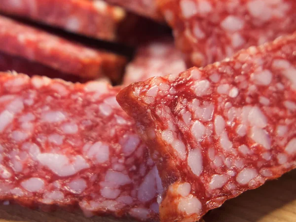 Smoked sausage, full frame. Pieces of appetizing meat snack close-up. Salami Background